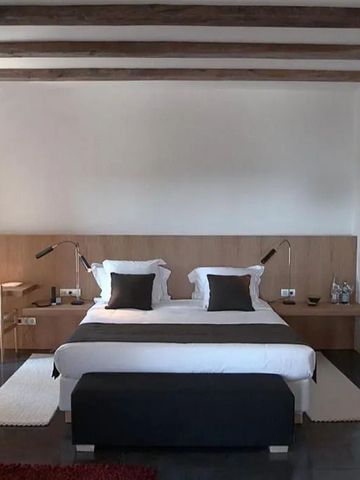 Elegantes Schlafzimmer mit Holzbalkendecke, Doppelbett und Schreibtisch