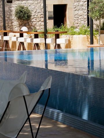 Infinity-Pool mit Blick auf eine stilvolle Bar und sonnige Terrasse