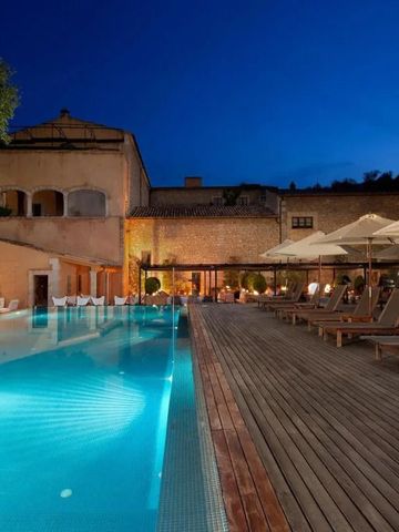 Beleuchteter Außenpool bei Nacht mit eleganter Holzterrasse und Liegen