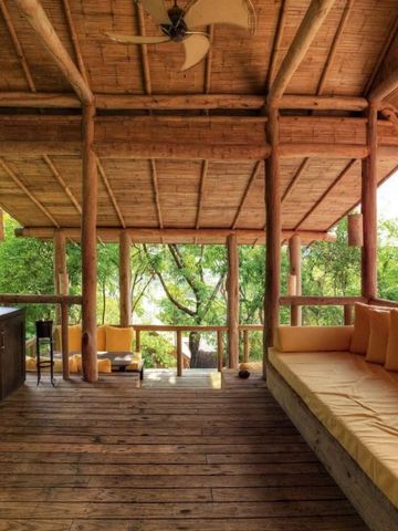 Offene Lounge mit Holzdekor und Gartenblick im Soneva Kiri