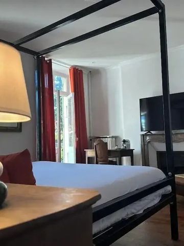 Großes Bett in elegantem Zimmer mit Kamin und TV