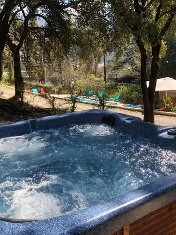 Whirlpool im Freien unter Bäumen mit Blick auf Liegestühle