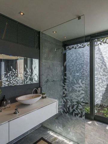 Badezimmer mit großem Spiegel und stilvoller Glasdusche