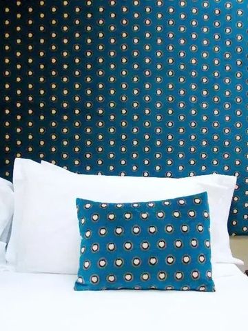 Stylisches Zimmer mit gepunktetem Muster und weißen Kissen