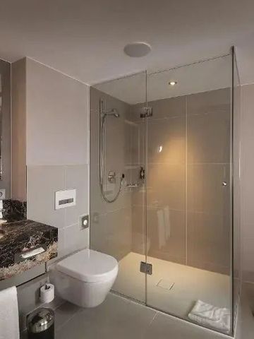 Helles Badezimmer mit großer Dusche und eleganten Armaturen