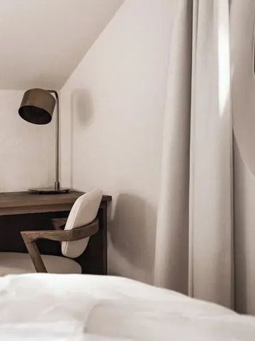 Gemütliches Schlafzimmer mit Schreibtisch und Sessel in natürlichem Licht
