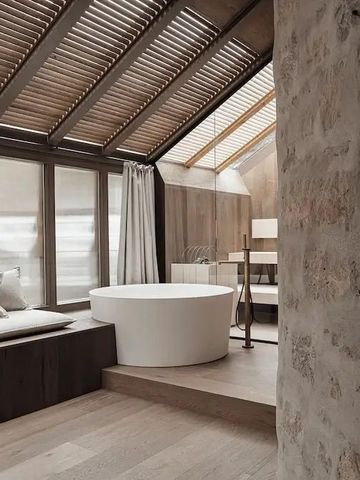 Modernes Badezimmer mit Sitzgelegenheit aus Holz und freistehender Badewanne.