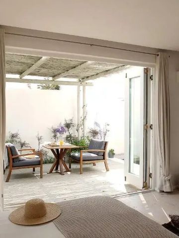 Zimmer mit Blick auf private Terrasse mit Tisch und Stühlen