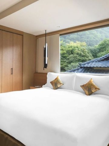Modernes Hotelzimmer mit großem Bett und Blick auf japanische Gärten