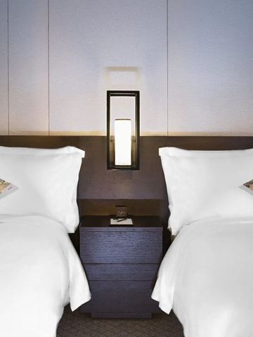 Stilvolles Hotelzimmer mit zwei Einzelbetten und dezenter Beleuchtung