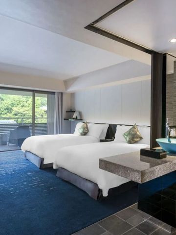 Luxuriöses Hotelzimmer mit Sitzbereich und Blick auf grüne Natur