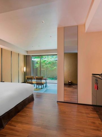 Geräumiges Zimmer mit Holzboden und großem Fenster zum Garten
