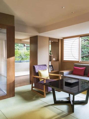 Geräumiges Wohnzimmer einer Suite mit modernen Möbeln und Blick auf den Garten