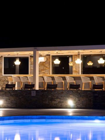 Nachtansicht einer stilvollen Hotelbar mit beleuchtetem Pool