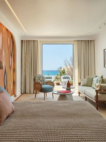 Zimmer mit Meerblick durch große Fenster und farbenfrohe Innenausstattung