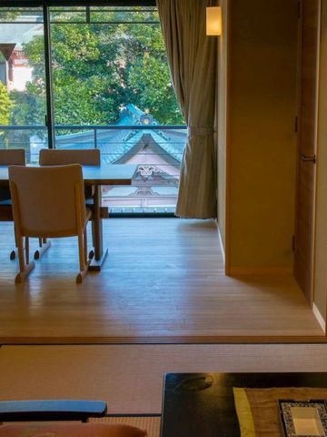 Japanische Suite mit Essbereich und Blick auf traditionelle Dächer