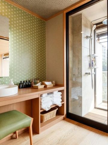 Luxe-Badezimmer mit Dusche und Blick auf die Natur durch eine Glaswand