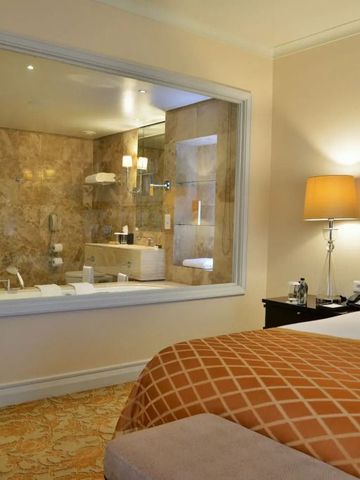 Luxuriöses Hotelzimmer mit Blick ins Badezimmer durch ein großes Fenster