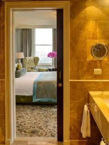 Luxuriöses Badezimmer mit Blick in ein elegantes Schlafzimmer