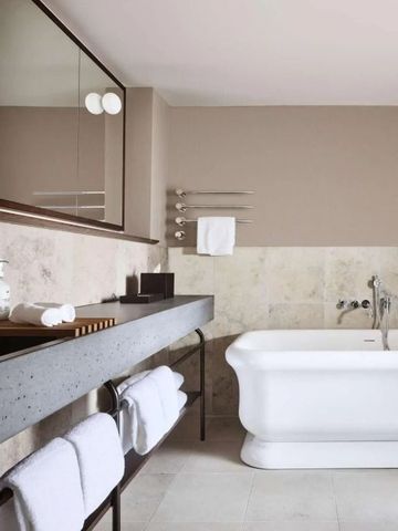Badezimmer mit freistehender Badewanne und großem Spiegel