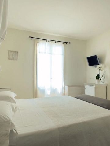 Geräumiges Zimmer in neutralen Farben mit Bett und TV