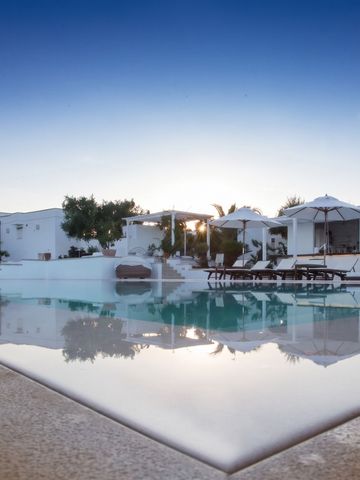 Infinity-Pool im Sonnenuntergang mit stilvoller Architektur im Hintergrund.