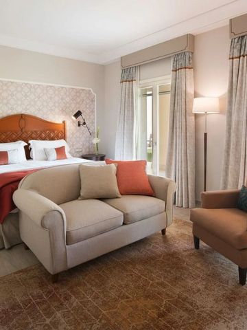 Helles Gästezimmer mit Doppelbett und gemütlicher Sitzecke