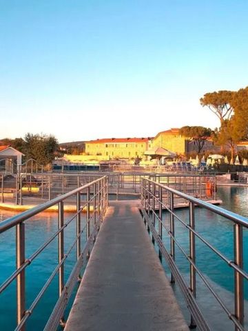 Freiluft-Poolbereich mit Steg vor dem Resort im Hintergrund bei Tageslicht
