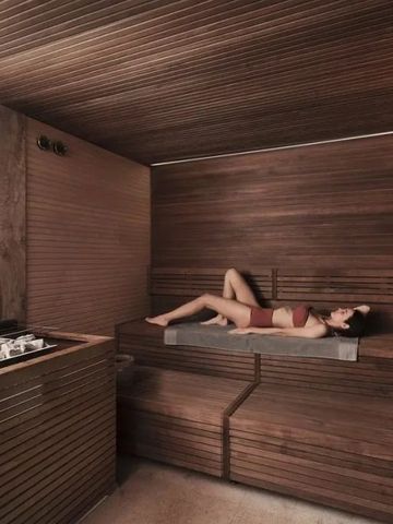 Elegante Sauna mit Liegeplatz aus Holz und gedämpftem Licht