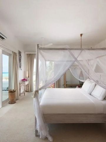 Helles Schlafzimmer mit Baldachin-Bett und Meerblick