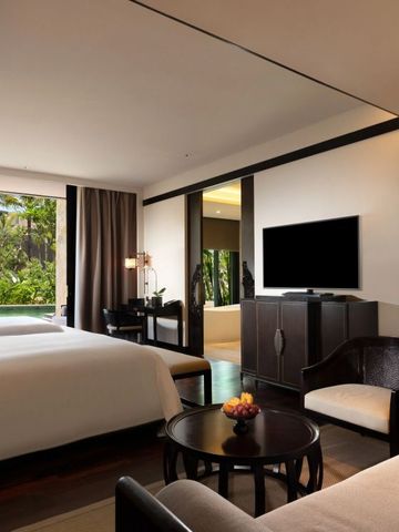 Luxuriöses Hotelzimmer mit zwei Betten und Blick auf einen grünen Garten