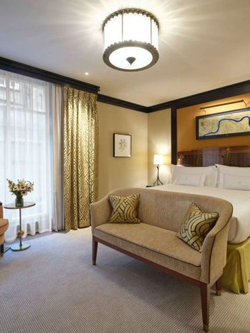 Elegantes Hotelzimmer mit Doppelbett und klassischer Einrichtung.