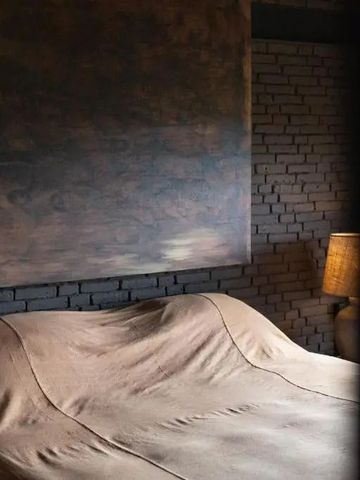 Gemütliches Hotelzimmer mit Kamin und rustikaler Ziegelwanddeko.