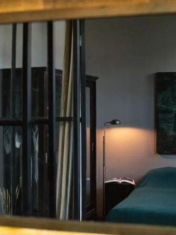Modern eingerichtetes Hotelzimmer mit Wandkunst und elegantem dunklem Mobiliar.