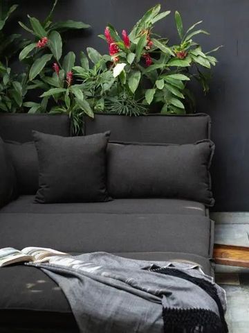 Lounge-Sofa mit Pflanzen und kleinem Pool im Hintergrund