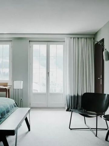 Modernes Hotelzimmer mit großem Bett, Fenster mit Blick und eleganter Einrichtung