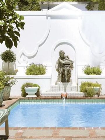 Kleiner Außenpool mit eleganter Skulptur und üppiger Begrünung