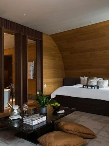 Geräumiges Hotelzimmer mit Holzwänden, Sitzbereich und offenem Badezimmer