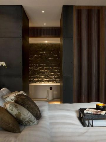 Helles Zimmer mit modernem Design, Akzenten aus Holz und Steinwand im Badezimmer