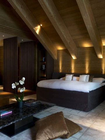 Luxuriöses Schlafzimmer im alpinen Stil mit Holzelementen und Doppelbett