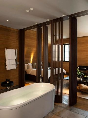Luxuriöses Badezimmer mit freistehender Badewanne und Holzvertäfelung