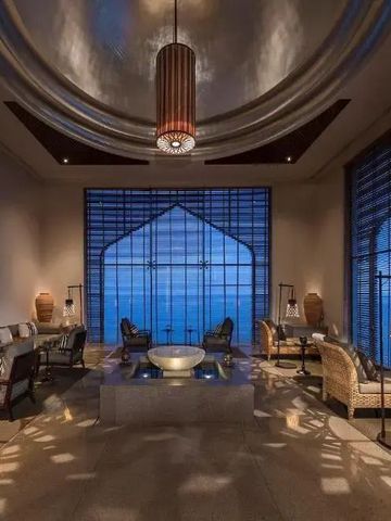 Elegante Lounge mit hohen Decken und großem Fenster bei Dämmerung