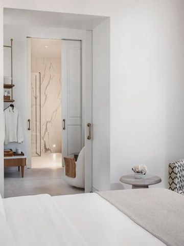Helles Schlafzimmer mit Blick ins Marmor-Badezimmer