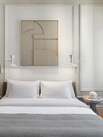 Modernes Schlafzimmer mit Kunstwerk und edlen Lampen