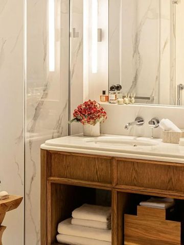 Luxuriöses Badezimmer mit Marmorwänden und eleganter Waschtisch.
