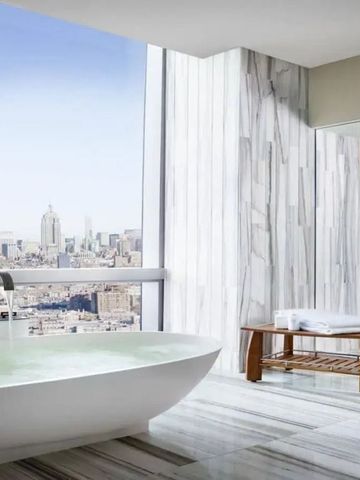 Modernes Badezimmer mit großer Badewanne und Blick auf die Stadt
