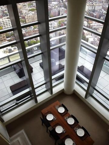 Blick von oben auf eine private Penthouse-Terrasse mit Esstisch und Stadtblick