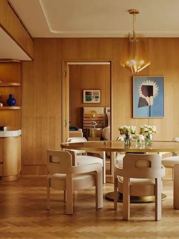 Stilvoller Essbereich mit Holzmöbeln und modernen Kunstwerken an der Wand