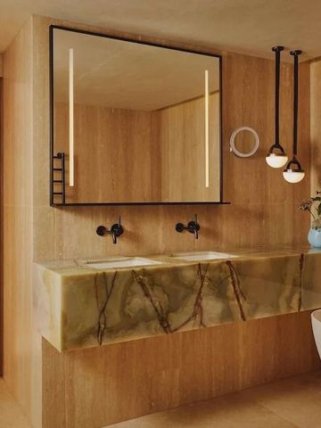 Modernes Badezimmer mit doppeltem Waschtisch aus Marmor und stilvollen Leuchten