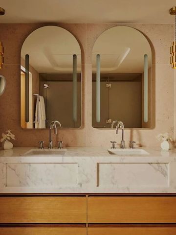 Helles Badezimmer mit Marmoroberflächen und eleganten Spiegeln